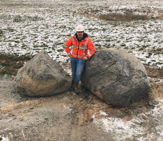 Provincie vindt 500 miljoen jaar oude zwerfkeien op Texel Dennis Duineveld, uitvoerder Waalenburg voor Combinatie Tessel, tussen de twee zwerfkeien. Ingezonden foto Provincie Noord-Holland.