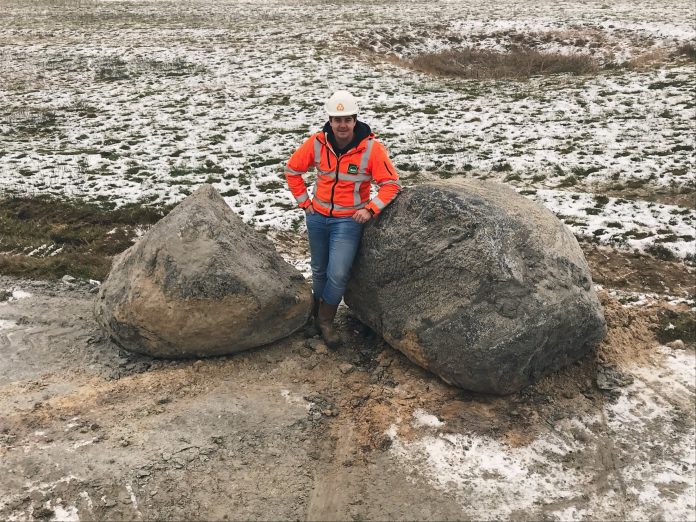 Dennis Duineveld, uitvoerder Waalenburg voor Combinatie Tessel, tussen de twee zwerfkeien. Ingezonden foto Provincie Noord-Holland.