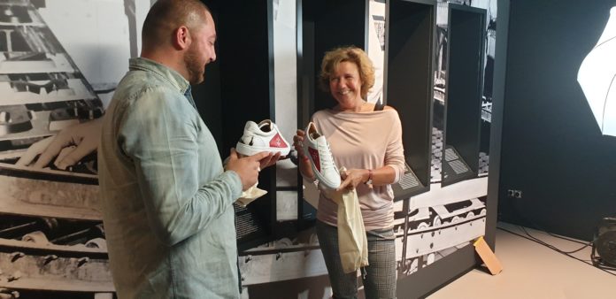 Kadir Kale overhandigt Museum Haarlem directeur Laura van der Wijden het eerste paar sneakers waarop de stad Haarlem is te zien. Ingezonden pr foto Museum Haarlem..
