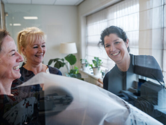 Wethouder van Loenen (rechts) aan de slag bij Stichting Nooit Voorbij met Anke Dorenbos (links) en Yvonne Woltjer van VWC-BUUV. &copy;Ramon Philippo van In the Picture