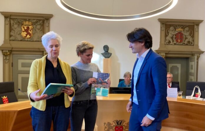Wethouder Roduner overhandigde de Programmabegroting aan raadleden Van Zetten (l. Hart voor Haarlem) en Klazinga (r. VVD). Wethouder Roduner overhandigde de Programmabegroting aan raadleden Van Zetten (l. Hart voor Haarlem) en Klazinga (r. VVD).