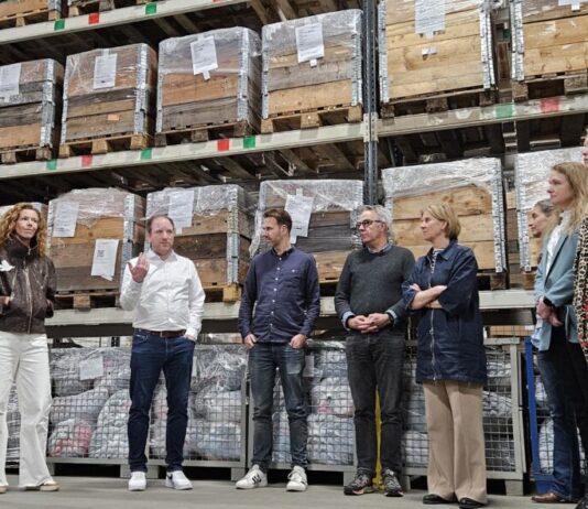 Werkbezoek Tweede kamerlid aan Spaarne Werkt Het gezelschap in het magazijn van het Textielsorteercentrum van Spaarne Werkt (foto: Spaarne Werkt).
