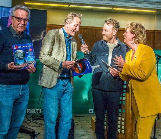 Lancering magazine ‘80 Jaar Vrijheid Haarlem’ trekt volle zaal en veel enthousiasme Jeannette Eversen (rechts) reikt eerste exemplaren uit - Fotografie: Franklin van der Erf.
