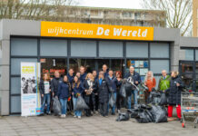 Burgemeester Wienen steekt samen met bewoners en team VWC-BUUV de handen uit de mouwen tijdens NLdoet 2026 De schoonmaakploeg met het verzamelde afval bij Huis van de Wijk De Wereld. Fotografie: Ramon Philippo-RAP Fotografie.