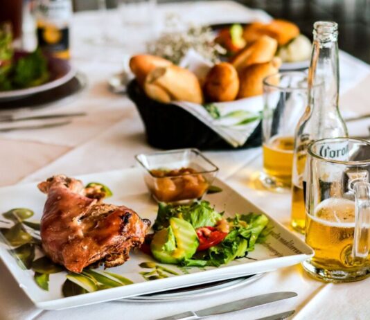 Samen aan tafel: Spaarnediners sluit zich aan bij Stem in de Stad A delightful dinner table setup featuring roast with salad, bread, and beer bottles.